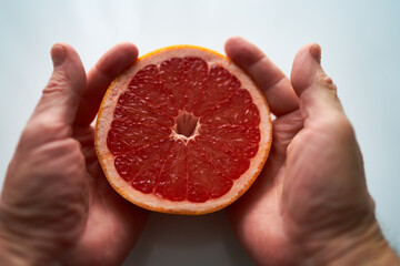 hand holding grapefruit on white background
