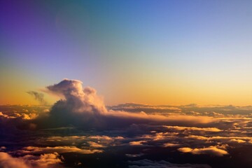 spectacular sunset seen from an airplane with clouds in the foreground and in the distance

