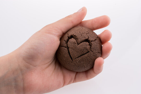 Close-up Of Hand Holding Cookie Over White Background