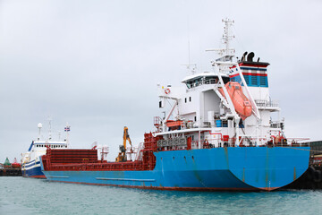 General Cargo Ship with blue hull is moored in port