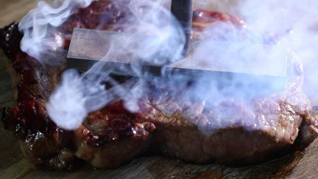 Close-up of steaming steak getting branded