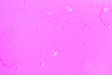Liquid pink gel with bubbles close-up, texture and background