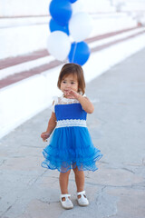 little girl in a beautiful dress with a huge fountain of balloons