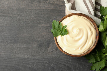 Bowl with mayonnaise, parsley and towel on dark background