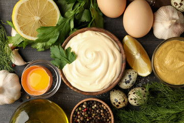 Wooden bowl of mayonnaise and ingredients for cooking, top view