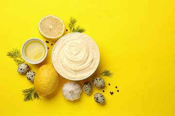 Bowl with mayonnaise and ingredients on yellow background