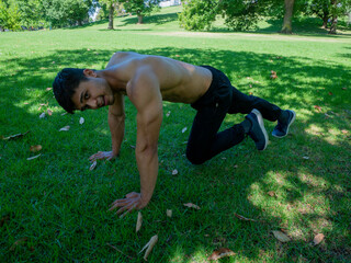 Young man doing statics abs at the park