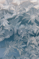 Frosty natural pattern on the winter window. The texture of ice on frozen glass.