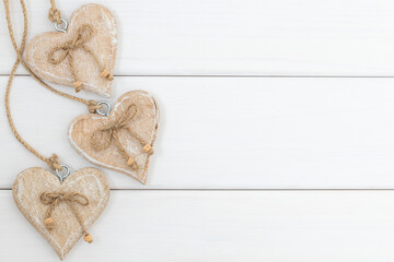 Three wooden  hearts on white wooden background 