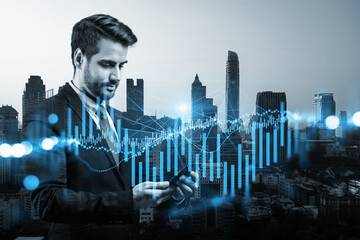 Handsome Caucasian trader checking quotes to forecast the capital market behavior. Concept of trading strategy. Forex chart. Bangkok. Double exposure.