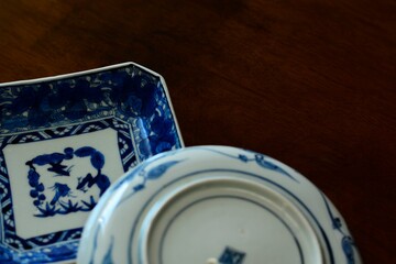 picture plate. This is a very fine example of Japanese traditional. lay out vintage ceramic “ imari ware ”. This antique walnut table is made in England.wooden background. soft focus image.