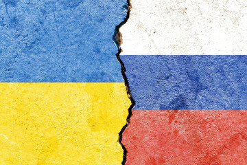 View of Ukraine vs Russia flags on cracked concrete wall - political partnership conflicts concept