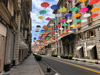 Colorful umbrellas hanging from above on the empty street