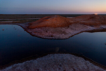 Dusk lake sunset in steppe on light background. Natural light. Sunset river water reflection