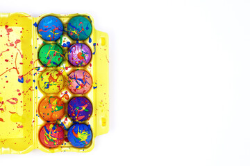 Fototapeta na wymiar Colorful Easter eggs painted with gouache in yellow egg box isolated on white background, top view copy space 