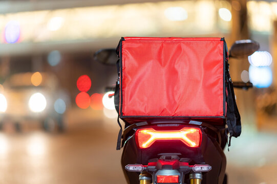 food delivery service ,A Large Red Bag pace on motorcycle in the city.