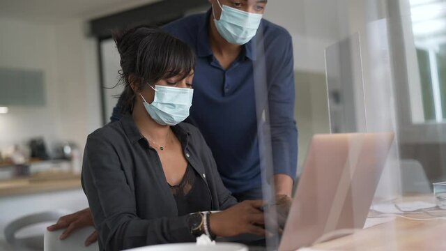 Start-up people working in co-working space office, wearing face mask during 19-ncov pandemic