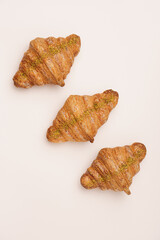 Tasty buttery croissants on the beige background. 