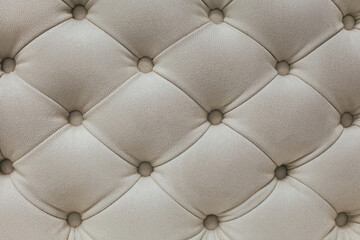 Light beige velour textile diamond pattern with buttons. Background concept. Furniture sofa cover.
