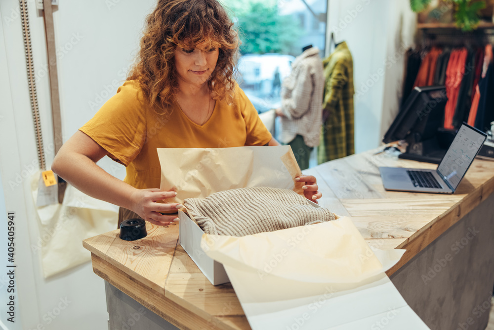 Wall mural businesswoman packing clothes for delivery