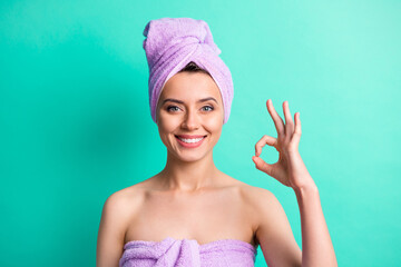 Photo of adorable lady after taking shower show okey symbol express approval wear violet towels isolated teal color background