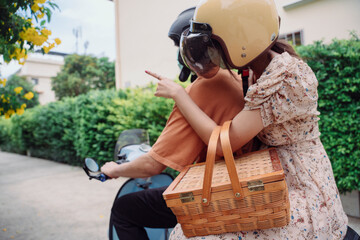 A motorbike taxi transports a passenger on a city street.
