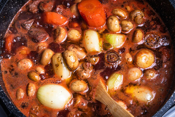 Cooking Burgundy beef in a saucepan on the stove close-up.