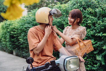 Asian thai couple wearing helmet standing with motorbike.