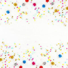Party colorful confetti over white wooden background . Top view, flat lay