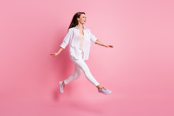 Full length photo of cute charming young woman dressed casual white clothes jumping isolated pastel pink color background