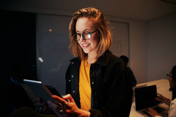 Portrait of a smiling young business woman using digital tablet in modern office