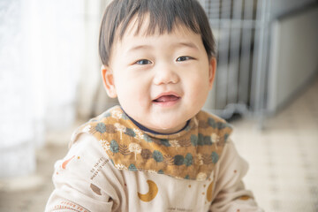 リビングでリモコンで遊ぶ赤ちゃん