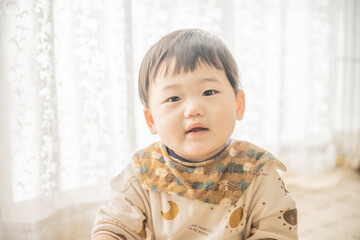 リビングでリモコンで遊ぶ赤ちゃん