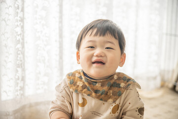 リビングでリモコンで遊ぶ赤ちゃん