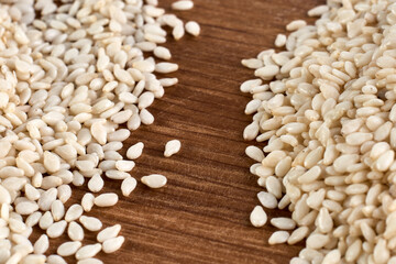 Close up of organic raw white sesame seeds on wooden background