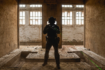 Fototapeta na wymiar Silhouette of a special forces operator in abandoned building during his cqb tactical training.
