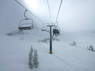 Fototapeta na wymiar Moody view of the chair lift and extreme terrain at a ski resort in california on a cloudy day