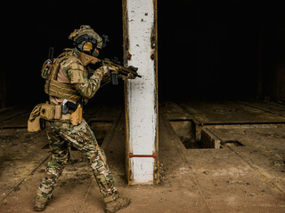 Special forces soldier doing tactical training in building clearing (CQB). He is wearing multicam...
