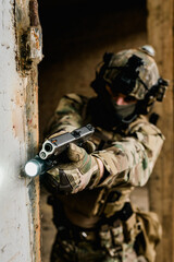 Special forces soldier doing tactical training in building clearing (CQB). He is wearing multicam uniform and XDM 9mm gun.