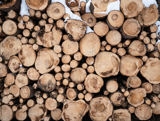 A pile of firewood in a snowy landscape, wood cut by a woodcutter in the forest.