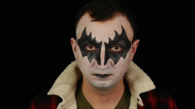 Portrait of man in demon makeup doing yes gesture while looking at the camera
