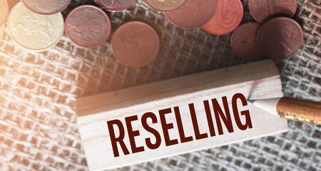 RESELLING word written on wooden building block and euro coins around. Trading reselling retail business concept