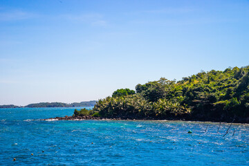 Naklejka premium Hon Thom island in Phu Quoc, Vietnam, Asia - Tropical view with colorful houses, blue waves and blue sky, fishing boats and far away is a longest cable car