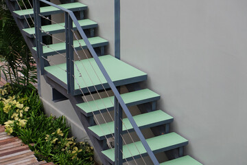 Outdoor stairs with handrails closed to the wall of building