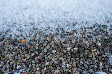Small gravel road covered in snow texture. Winter pebble background. Dirty road. Fros morning. Snowy land