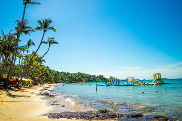 Beautiful landscape of Hon Thom beach, Phu Quoc island, Vietnam, Asia with tourist, chairs and umbrella. White sand and coco palms travel tourism and swing under tree.