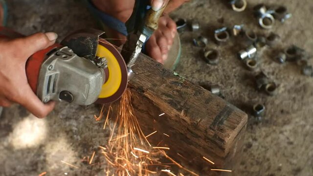Man's Hand Smooths The Hinges Using A Grinding Machine