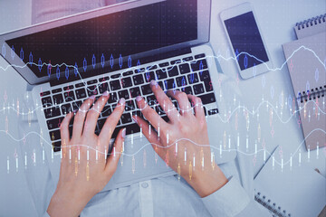 Double exposure of woman hands working on computer and forex chart hologram drawing. Top View. Financial analysis concept.