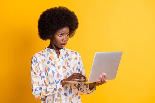 Photo of impressed sad dark skin lady dressed casual outfit holding looking modern gadget isolated yellow color background