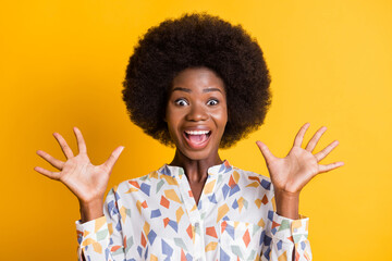 Portrait of delighted positive person open mouth arms palms up great result isolated on yellow color background